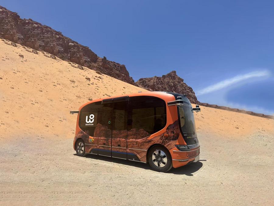 في الصورة الملتقطة يوم 25 مايو 2025، حافلة كهربائية صغيرة ذاتية القيادة طورتها شركة "وي رايد" الصينية، تُسير رحلات في مدينة العلا التاريخية بالسعودية. (شينخوا)