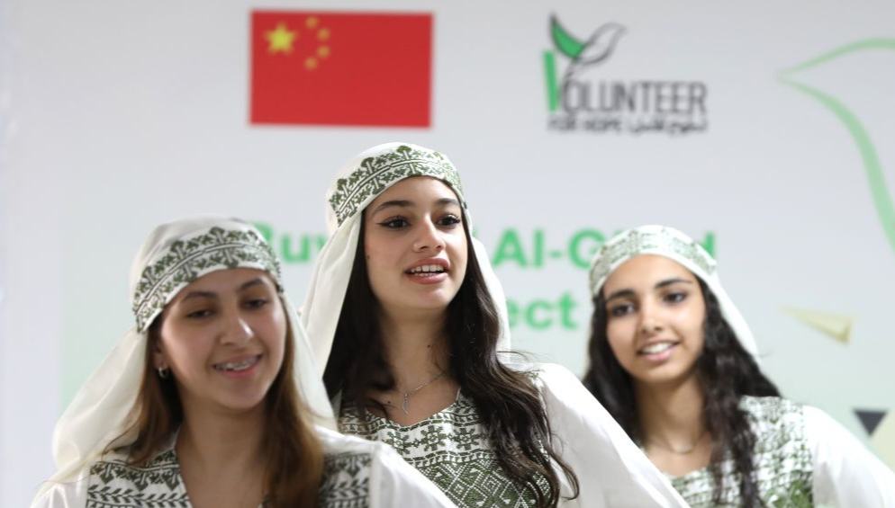 في قاعة مقر جبهة النضال الشعبي الفلسطيني بمدينة رام الله في الضفة الغربية، كانت الطفلة الفلسطينية جنى رائد، ترتب غطاء رأسها وتنتظر دورها للصعود إلى المسرح خلال حفل اختتام مشروع تعليمي بتمويل صيني.
